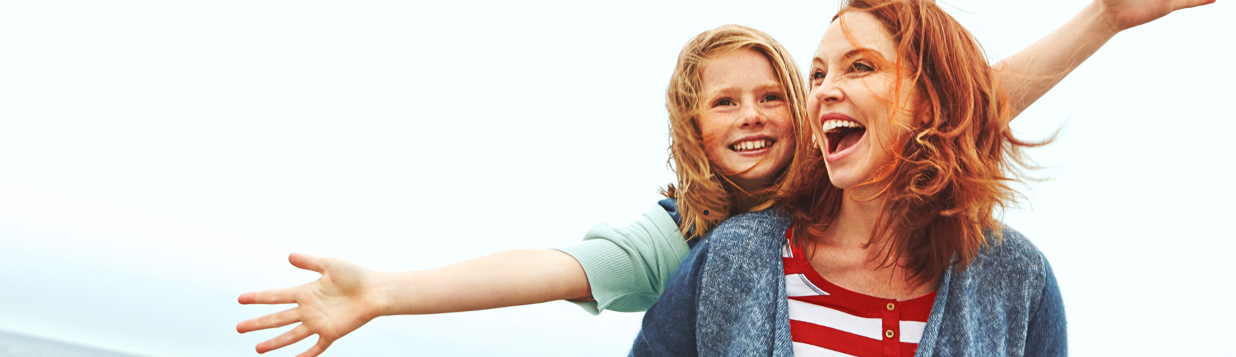 Woman with young girl behind with arms out stretched