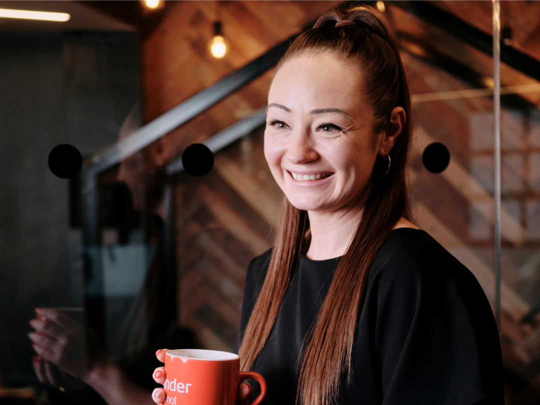 Work Cafe personal banker stood holding red mug