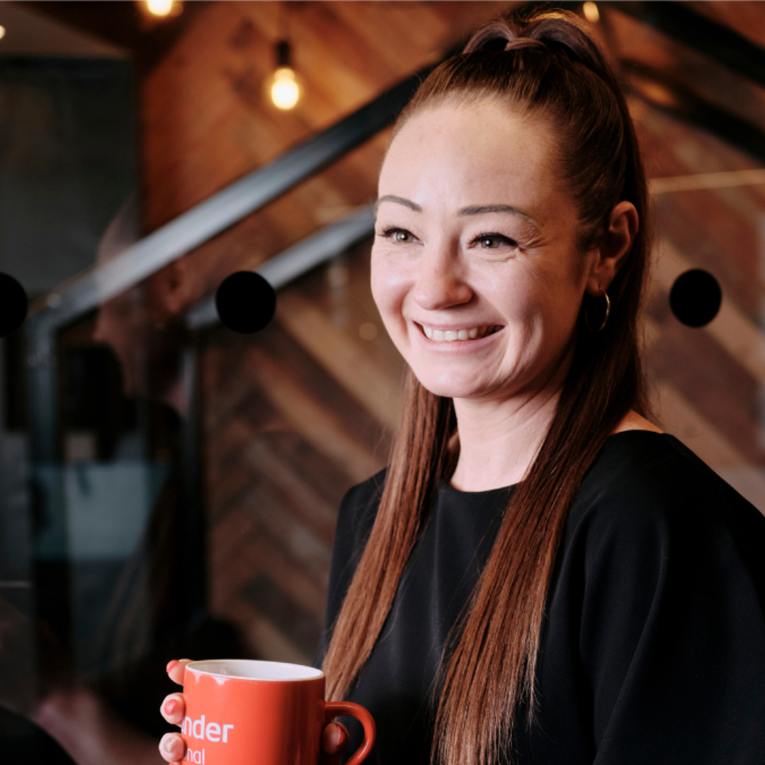Work Cafe personal banker stood holding red mug