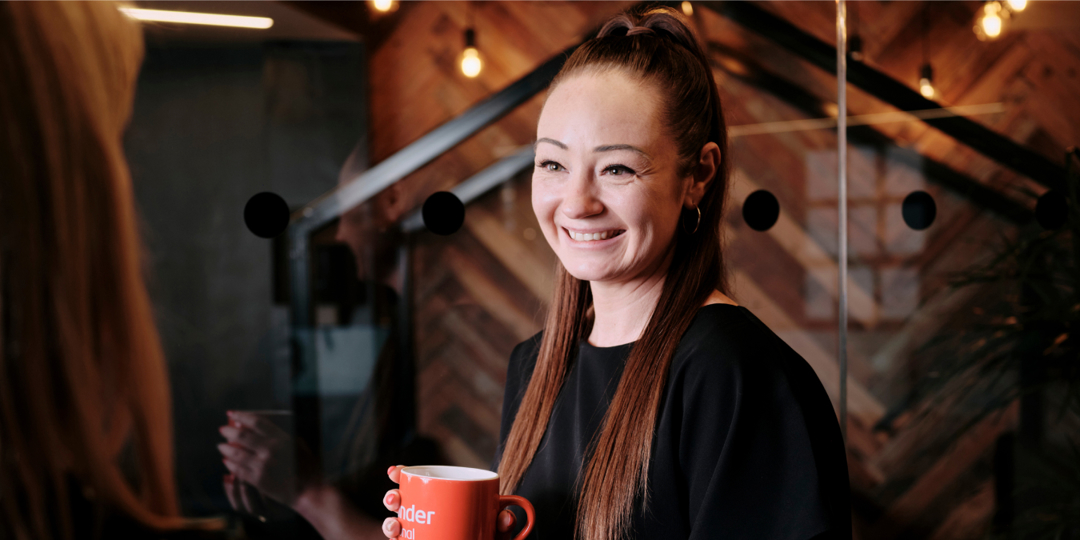 Work Cafe personal banker stood holding red mug