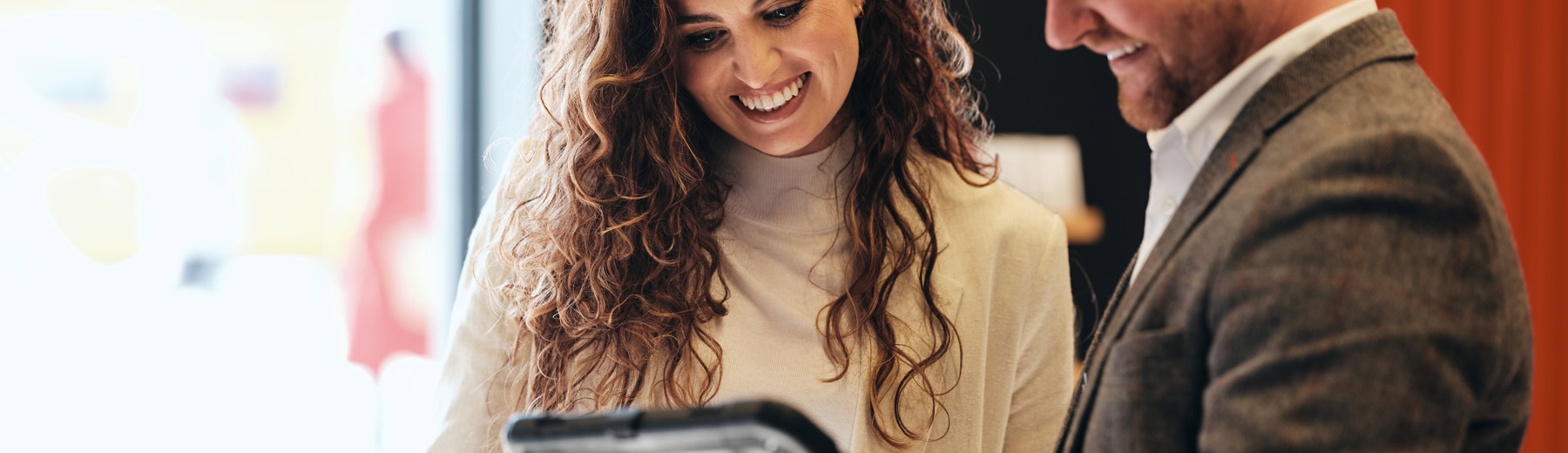Man with iPad stood talking to woman in Work Cafe