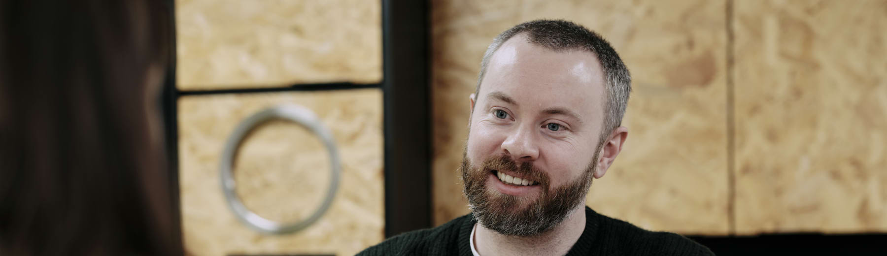 Man sat opposite woman at table with red mug