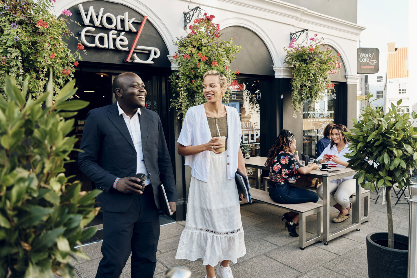 Couple with takeaway coffees outside Jersey Work Cafe 