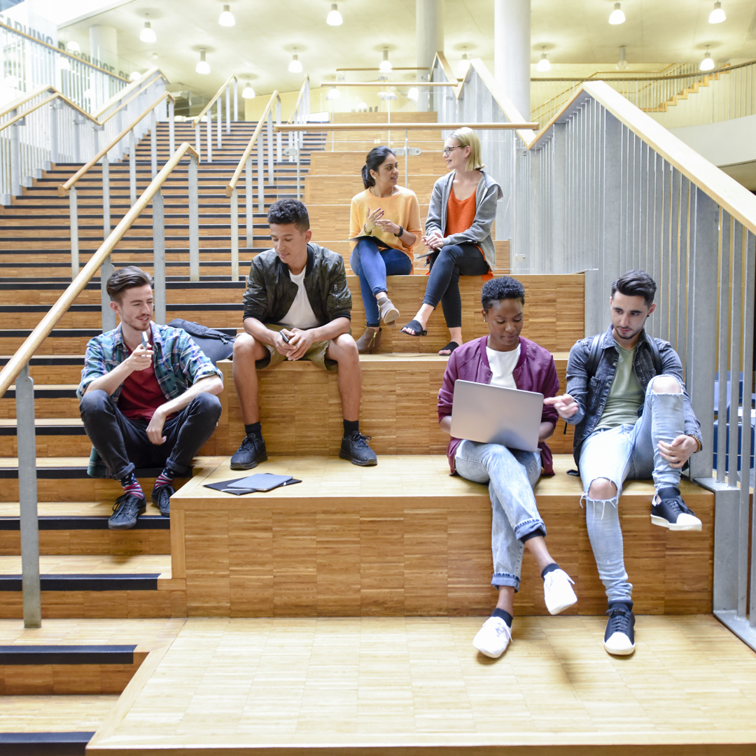 Students sitting on staircase in college